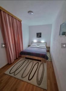 - une chambre avec un lit et un rideau rouge dans l'établissement Apartman Jezerce 71, à Jezerce