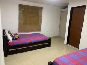 1 dormitorio con 2 camas y ventana. en Balcones de la Casona, en Guatapé