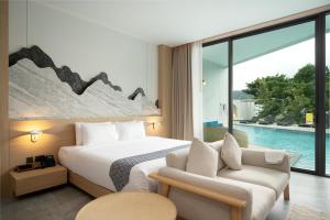 Timberton Resort Khaoyai في Ban Tha Maprang: غرفه فندقيه بسرير ومسبح