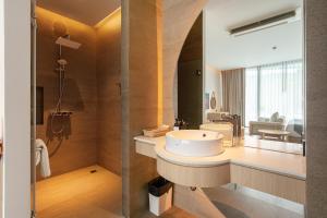 ein Bad mit einem Waschbecken und einem Spiegel in der Unterkunft Timberton Resort Khaoyai in Ban Tha Maprang