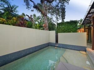 uma piscina ao lado de uma cerca branca em Cassowary Villa 1 - Short Walk to Beach and Town em Port Douglas