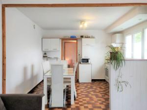 a kitchen and dining room with a table and chairs at Le clos Fleuri in Lescar