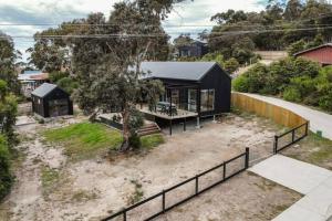 a house with a black roof at Winston's Beach House in Bicheno