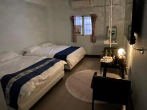 鹿港的住宿－鹿港宏旭民宿，一间卧室配有两张床和一张带台灯的桌子