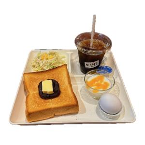 una bandeja con tostadas, un huevo y una bebida en The Kitchen Hostel Ao en Naha