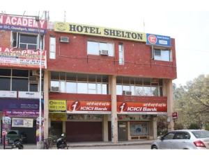 a hotel building with a car parked in front of it at Hotel Shelton, Chandigarh in Chandīgarh