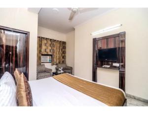 a hotel room with a bed and a television at Hotel Shelton, Chandigarh in Chandīgarh