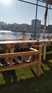 a wooden bench sitting next to a body of water at Onaty Narty Guest house in Aswan