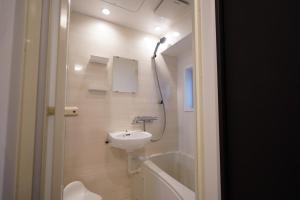 W łazience znajduje się umywalka i prysznic. w obiekcie Penthouse 1-bedroom flat in Hiroo Shibuya w Tokio