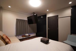 sypialnia z łóżkiem i telewizorem na ścianie w obiekcie Penthouse 1-bedroom flat in Hiroo Shibuya w Tokio