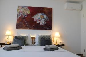 een slaapkamer met een bed met een schilderij aan de muur bij Villa SEVEN in Vir