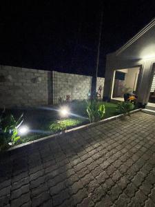 a house with lights in a yard at night at Your home away from home in Lusaka