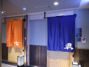a door in a room with a curtain and a door with a door at Dormy Inn Ueno Okachimachi in Tokyo