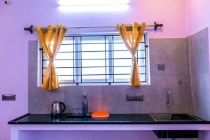 eine Küche mit einem Waschbecken und einem Fenster in der Unterkunft 1BHK villa with swimming pool @ Dreamland in Kottakupam
