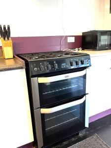 - un four noir installé au-dessus d'un comptoir de cuisine dans l'établissement Mango at the Lake sleeps 8, à Mangakino