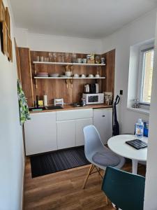 ボガーチにあるLaguna apartman Bogácsの白いキャビネット、テーブル、テーブル付きのキッチンが備わります。