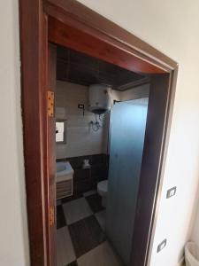 a small bathroom with a toilet and a door at Santa maria dahab hotel in Dahab