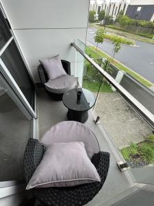 a balcony with two chairs and a table and a window at Mermaid - Magic king unit in Gold Coast