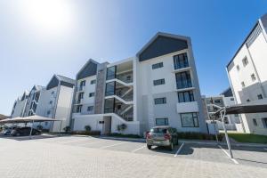 un coche aparcado delante de un edificio en First Class Apartment At Bella, en Summerstrand