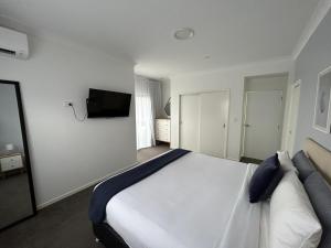 1 dormitorio con 1 cama y TV en la pared en Mermaid - Magic king unit en Gold Coast