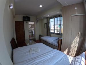 Habitación pequeña con cama y ventana en Hotel Global Village en Katmandú