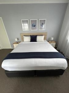 a large bed in a bedroom with two night stands at Mermaid - Magic king unit in Gold Coast