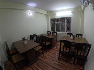 comedor con mesas y sillas de madera en Hotel Global Village en Katmandú