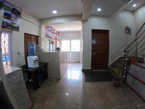 a living room with a staircase and a room with a kitchen at Hotel Global Village in Kathmandu