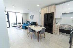 Una cocina y una sala de estar con mesa y sillas. en First Class Apartment At Bella, en Summerstrand 36 fotos más