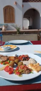 a table with two plates of food on it at NubaNile Guesthouse in Shellal
