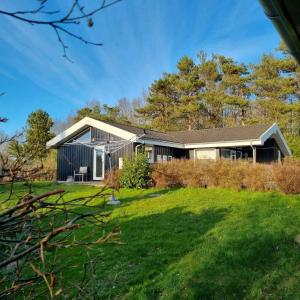 uma casa com um grande quintal com relva em Excellent Cottage With Sauna And Spa, 10 Persons, em Højby