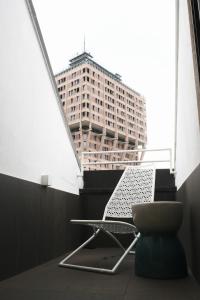 una sedia in una stanza con un edificio alto di ComeCasa 2 bedrooms Larga apartment a Milano