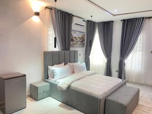 a bedroom with a bed with a gray headboard at Luxe Haven Lekki in Lekki