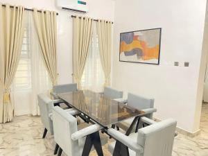 a dining room with a glass table and chairs at Luxe Haven Lekki in Lekki
