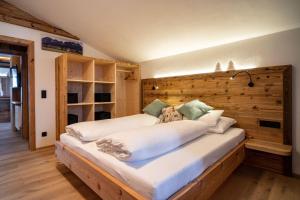 Schlafzimmer mit einem großen Bett mit einem Kopfteil aus Holz in der Unterkunft Finks Appartement in Going