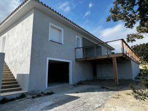 uma casa branca com uma varanda e uma garagem em Villa pedicervu haut em Ventiseri