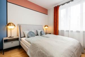 a bedroom with a large white bed with two lamps at Maple Tree Premium Apartment Mokotow in Warsaw