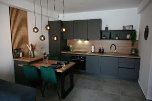 a kitchen with a table and blue cabinets and a dining room at ADRIANIK Apartment in Zagreb