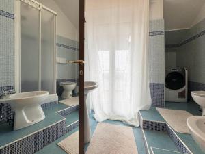 un bagno blu e bianco con due lavandini e una doccia di ComeCasa 2 bedrooms Larga apartment a Milano
