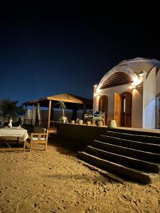 a building with stairs and a porch at night at NubaNile Guesthouse in Shellal