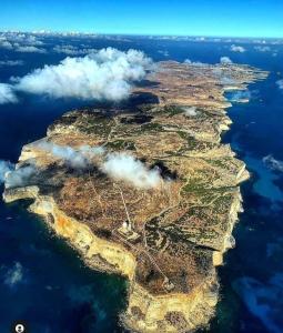 Un'isola nell'oceano con le nuvole sopra. di Lampedusa Low Prices a Lampedusa