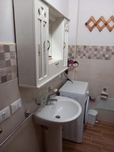 bagno con lavandino, servizi igienici e specchio di Lampedusa Low Prices a Lampedusa