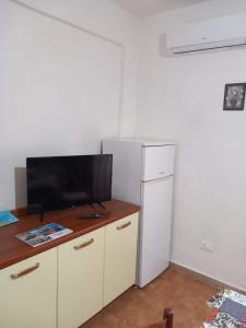 a kitchen with a television and a desk with a refrigerator at Lampedusa Low Prices in Lampedusa