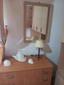 a dresser with a lamp and a mirror on it at Lampedusa Low Prices in Lampedusa