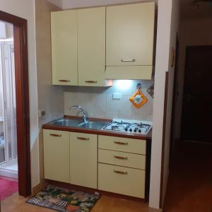 a kitchen with white cabinets and a sink at Lampedusa Low Prices in Lampedusa