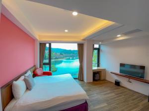 una camera d'albergo con un letto e una grande finestra di Zhaohong homestay a Yuchi