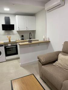 sala de estar con sofá y cocina en Apartamento Baeza 4B, en Baeza