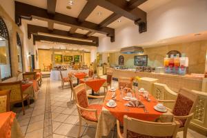 a restaurant with tables and chairs and a kitchen at Hotel Globales Camino Real Managua in Managua