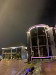 a large building with purple lights on it at night at Infinite luxury hotels and suites in Okinano