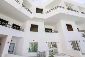 un gran edificio blanco con escaleras y ventanas en La bonita compound, en Hurghada